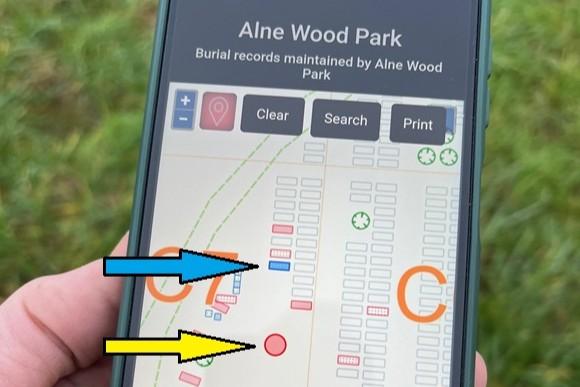 Alne Wood Park HeritEDGE onsite Hand holding a smartphone whilst onsite at the cemetery with the user locating their position on the map enabling them to locate a specific plot